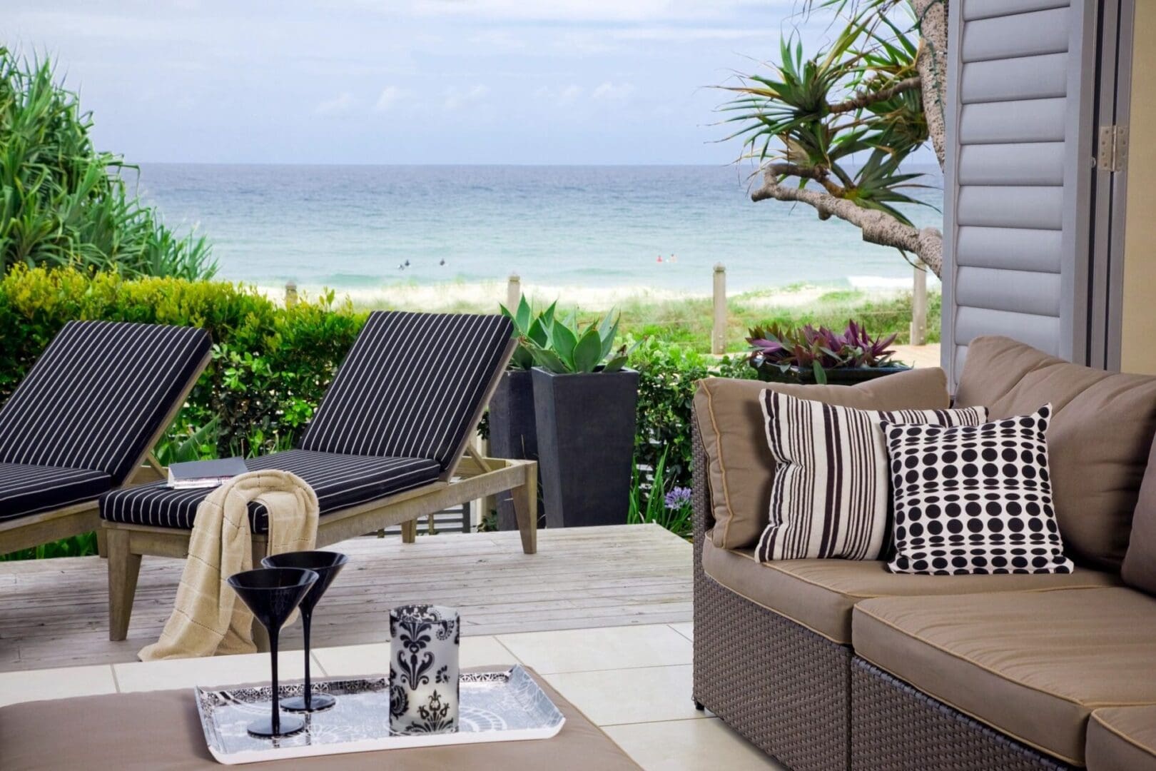 A patio with chairs and tables overlooking the ocean.