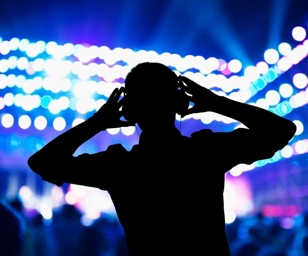 A man with headphones in front of a crowd.