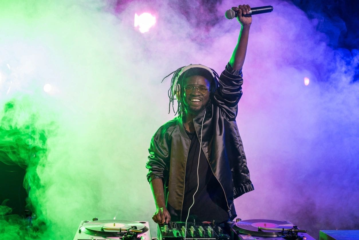 A man with dreadlocks is holding up his microphone.