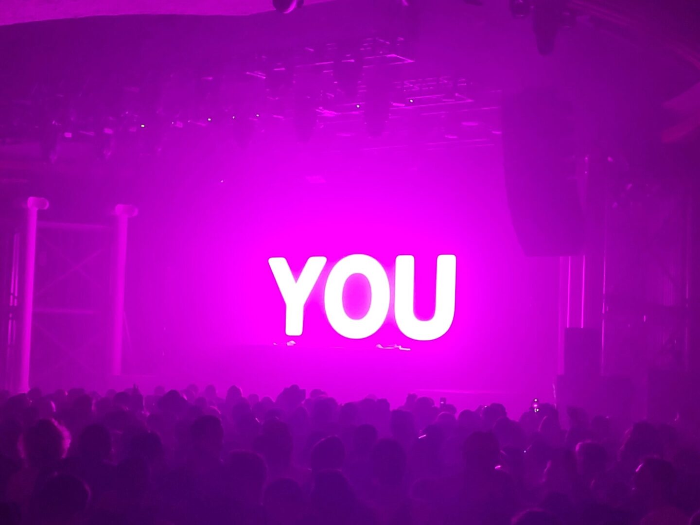 Pink stage lights; "YOU" in large letters.