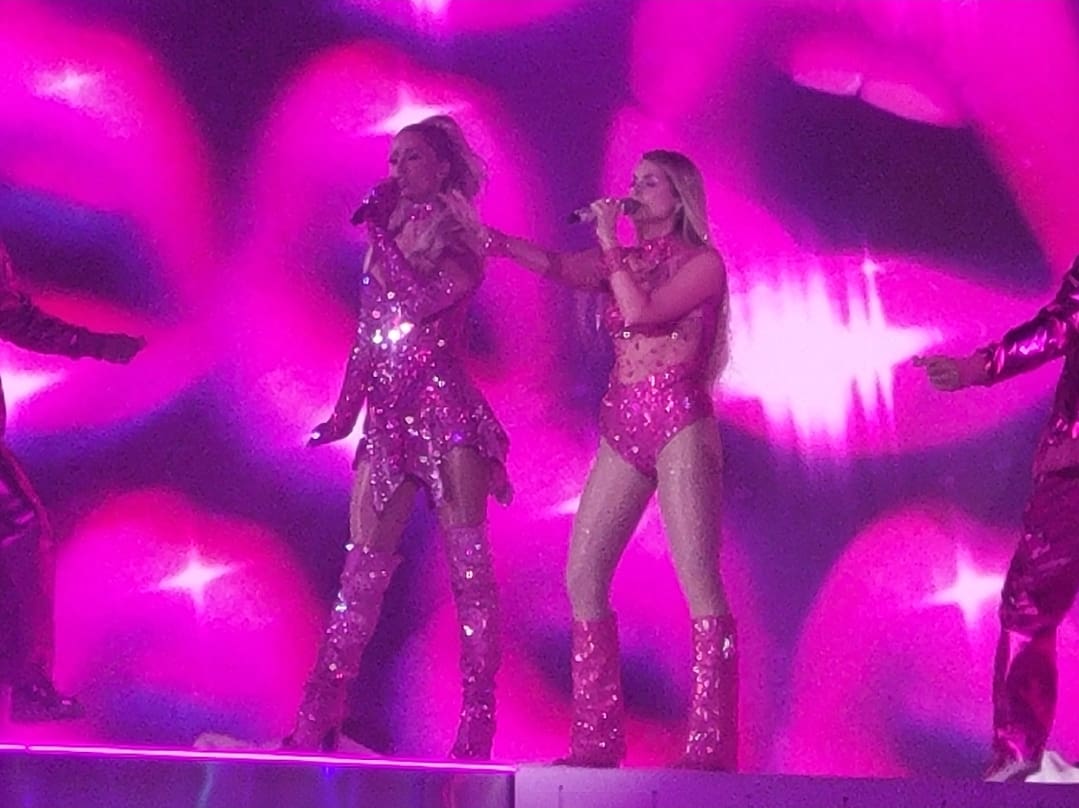 Two singers in pink sparkly outfits.