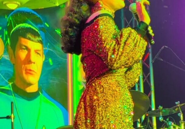 Singer in sequined gown holding microphone