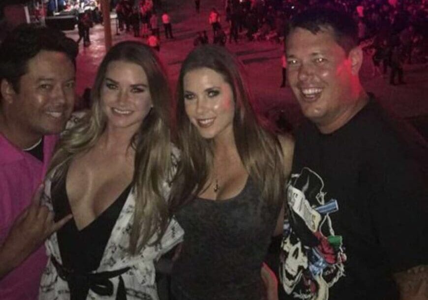 Four people smiling at outdoor nighttime concert