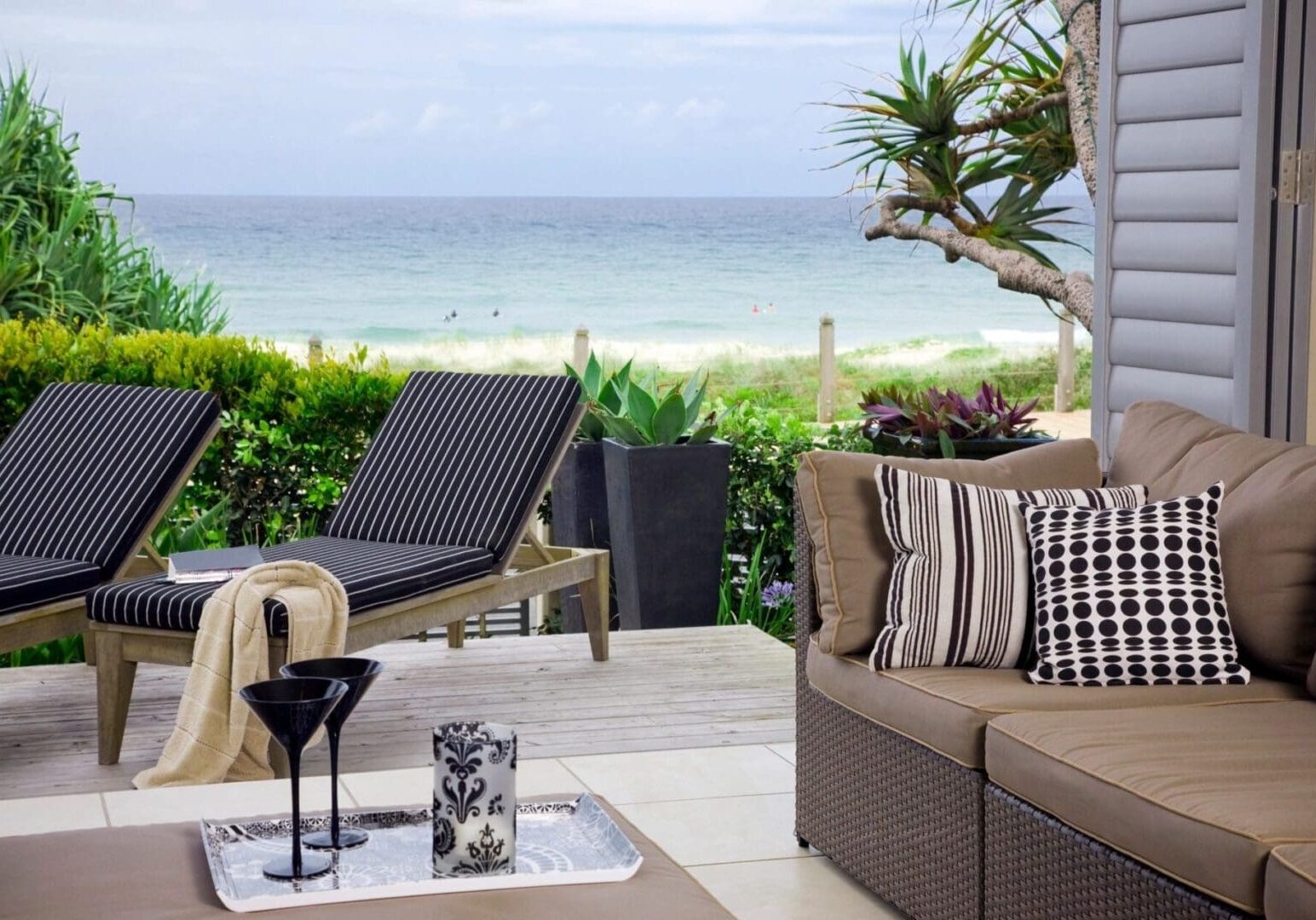 A patio with chairs and tables overlooking the ocean.