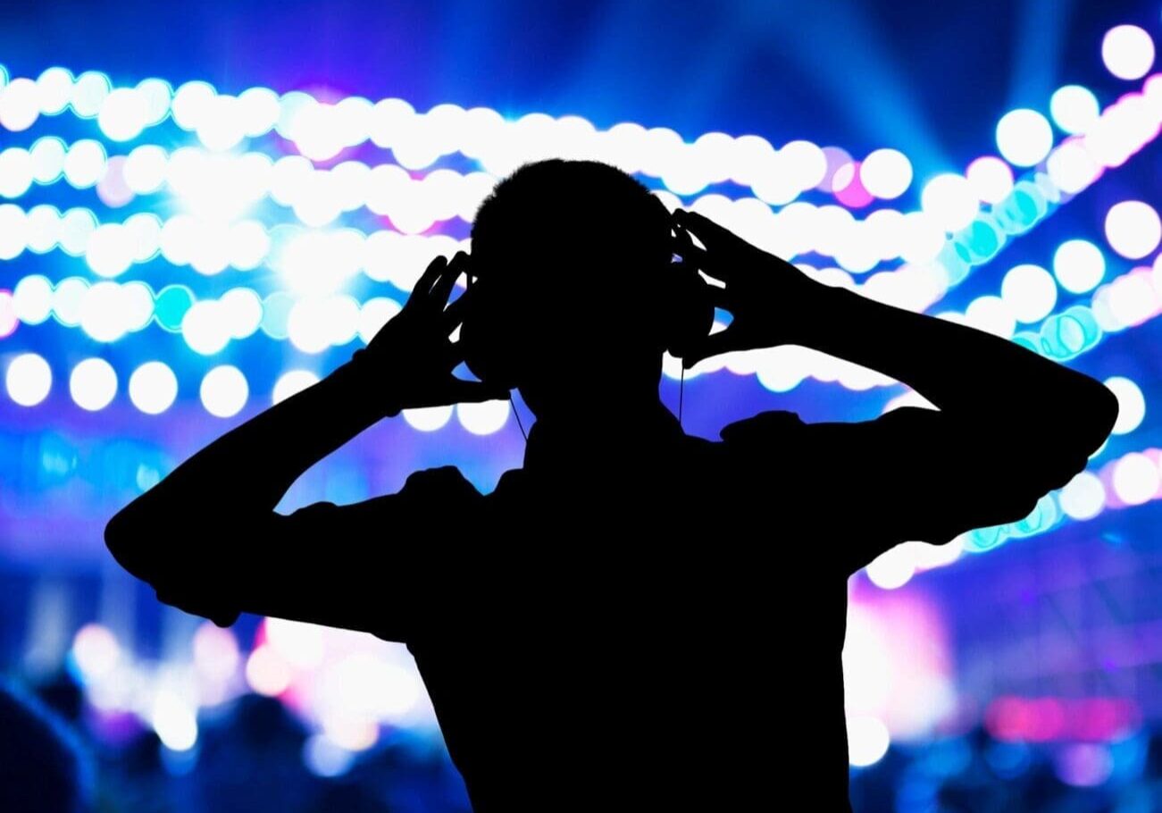 A man with headphones in front of a crowd.