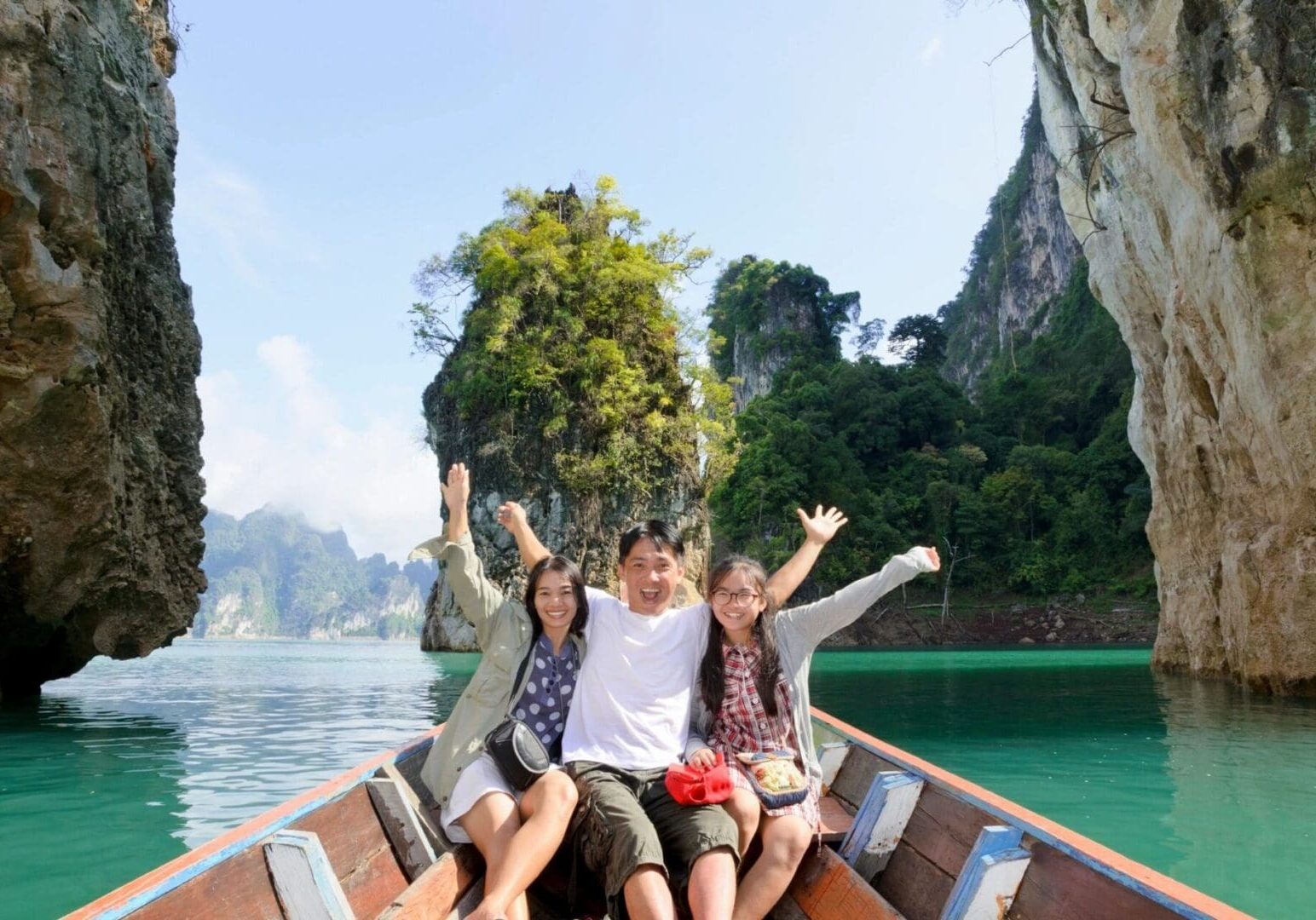 Three people are sitting on a boat in the water.