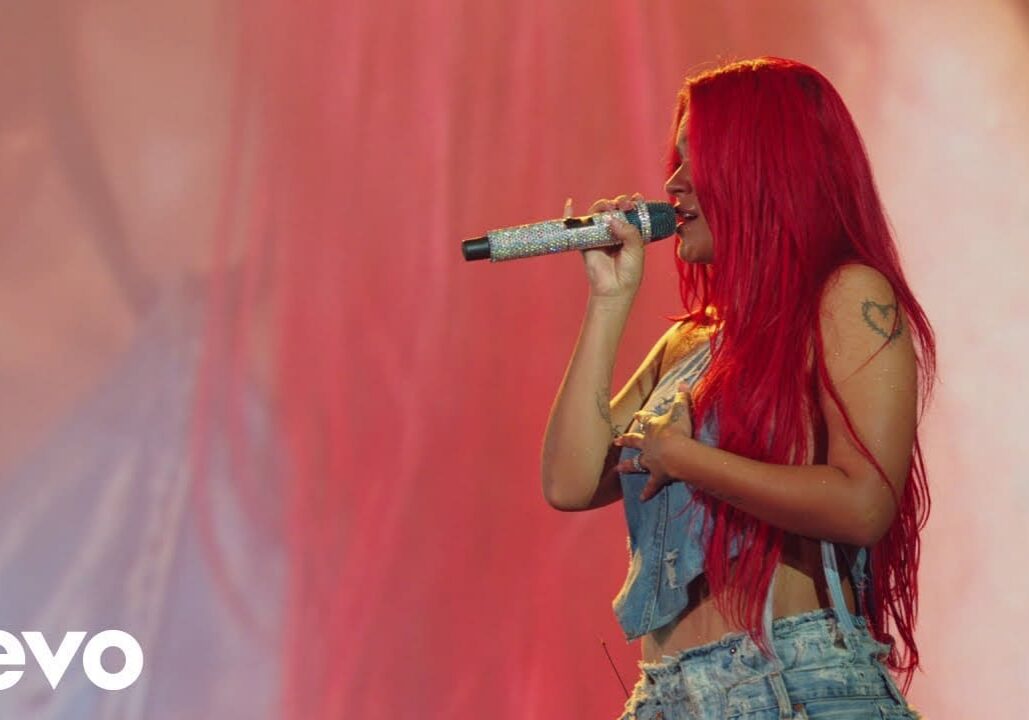 Singer with red hair performing on stage.